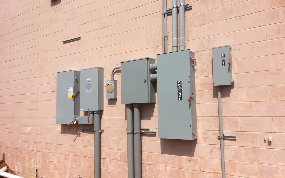 Disconnect switches and a meter mounted with conduit on the brick wall of a commercial building
