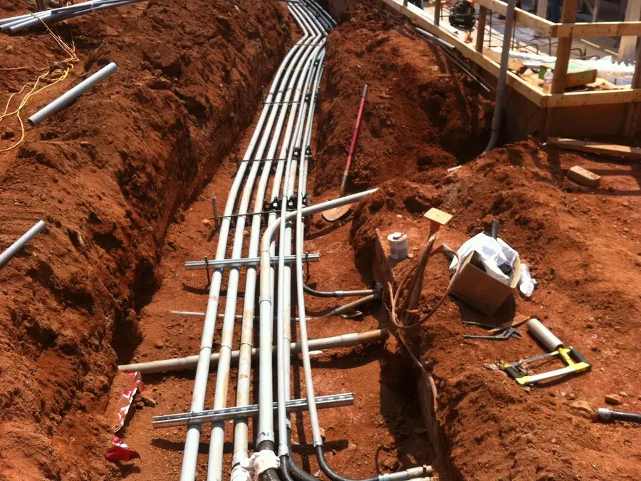 Electrical conduit runs laid in a trench of red Georgia clay